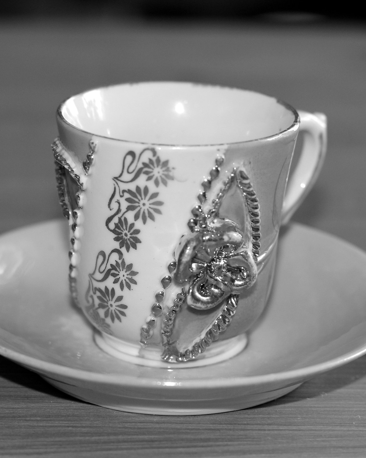A decorated porcelain coffee cup resting on its saucer